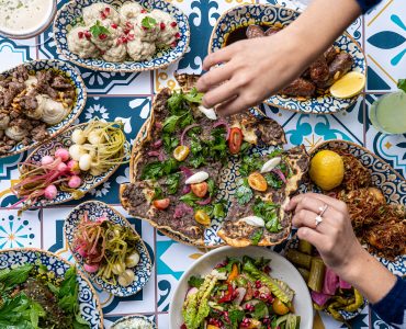 Hands reach for a Middle Eastern feast